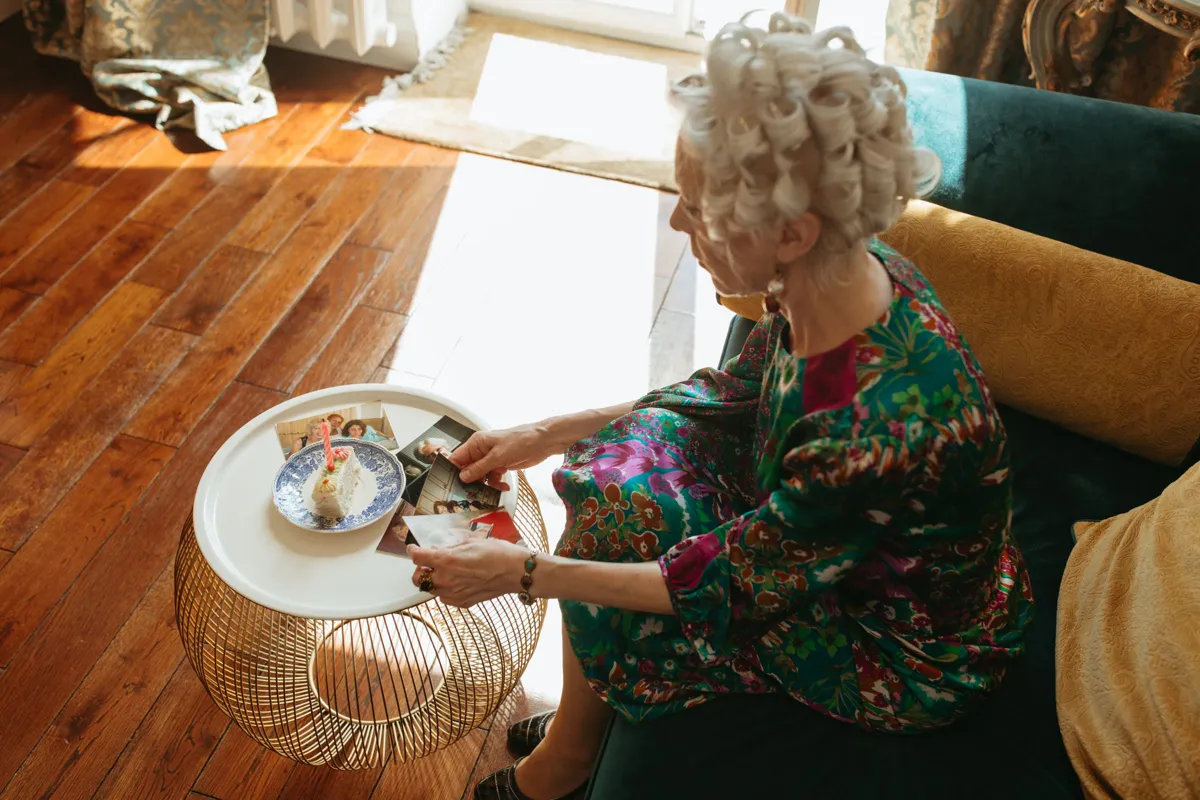 Femme âgée regardant des photos anciennes dans son salon